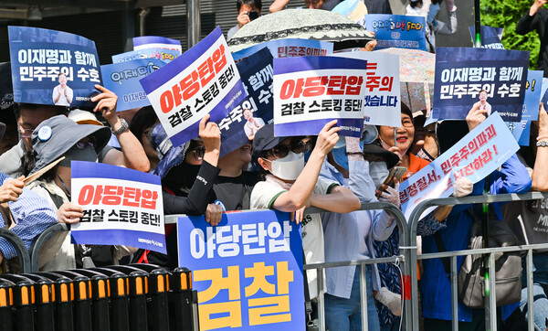 더불어민주당 이재명 대표가 '쌍방울 그룹 대북 송금' 의혹 관련 피의자 신분으로 조사를 받기 위해 검찰에 출석하는 12일 오후 경기도 수원시 영통구 수원지방검찰청 앞에서 이 대표 지지자들이 피켓을 들고 있다(이미지-연합뉴스)