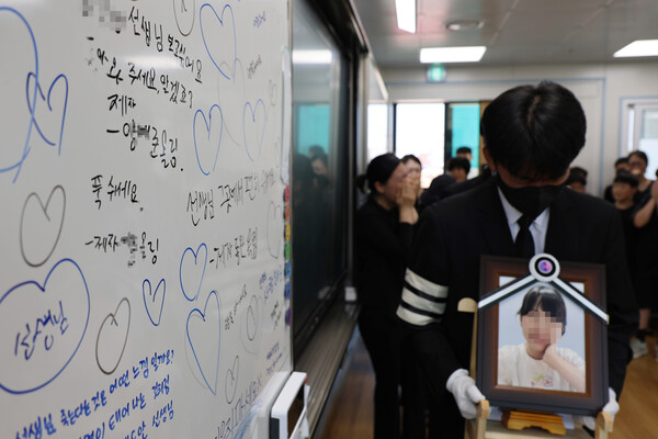 ▲ 악성민원으로 세상을 뜬 대전 초등 교사의 유족들이 9일 오전, 교사가 재직하던 유성구 한 초등학교 5학년 교실에 영정사진을 들고 들어서고 있다.(사진=연합뉴스)  