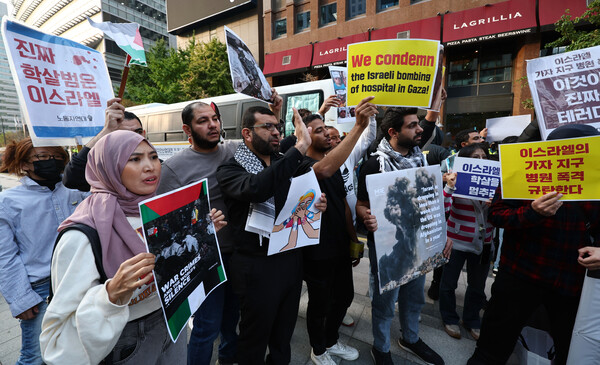 18일 오후 서울 종로구 주한 이스라엘 대사관 앞에서 열린 이스라엘의 가자 지구 병원 폭격 규탄 긴급 기자회견에서 팔레스타인을 비롯한 아랍인들이 손팻말을 들고 있다(연합뉴스)
