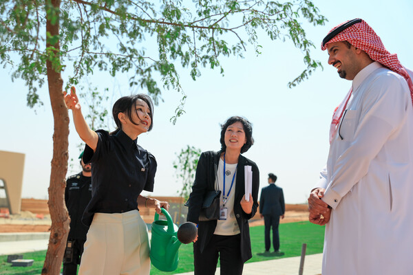 사우디아라비아를 국빈 방문 중인 윤석열 대통령의 부인 김건희 여사가 23일(현지시간) 리야드의 '그린 리야드 프로젝트' 현장인 사이언스파크 부지에서 한·사우디 수교 61주년을 기념해 사이언스파크에 심은 나무 61그루 중 마지막 한 그루를 식수한 뒤 나뭇잎을 만져보고 있다(연합뉴스)