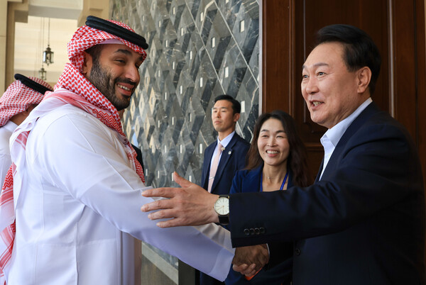 윤석열 대통령이 24일(현지시간) 사우디아라비아 리야드 영빈관을 방문한 빈 살만 사우디 왕세자와 악수하고 있다. 윤 대통령과 빈 살만 왕세자는 환담 후 미래 투자 이니셔티브 포럼 대담 행사장으로 함께 이동했다(연합뉴스)