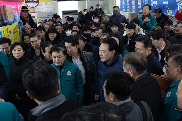 윤석열 대통령이 23일 충남 서천군 서천읍 서천특화시장 화재 현장에서 피해 상인들과 만나 대화하고 있다(연합뉴스)