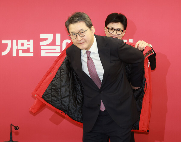 국민의힘 한동훈 비상대책위원장이 29일 오전 여의도 중앙당사에서 열린 국민인재 영입 환영식에서 신동욱 TV조선 전 앵커에게 당 점퍼를 입혀주고 있다. /사진제공=연합뉴스