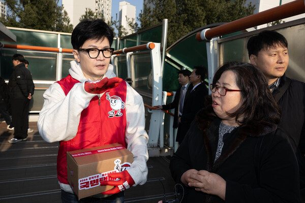 국민의힘 한동훈 비상대책위원장이 31일 경기도 수원시 장안구 보도육교에서 주민들의 애로사항을 듣고 있다.(연합뉴스)