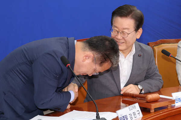 더불어민주당 이재명 대표가 19일 오전 서울 여의도 국회에서 열린 최고위원회에서 새로 지명된 강민구 최고위원과 악수하고 있다(연합뉴스)