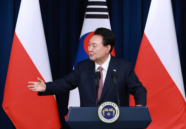 윤석열 대통령이 24일 서울 용산 대통령실에서 안제이 두다 폴란드 대통령과 한·폴란드 공동언론발표를 하며 참모진을 향해 즉석으로 취재진의 질문을 받겠다고 말하고 있다(연합뉴스)