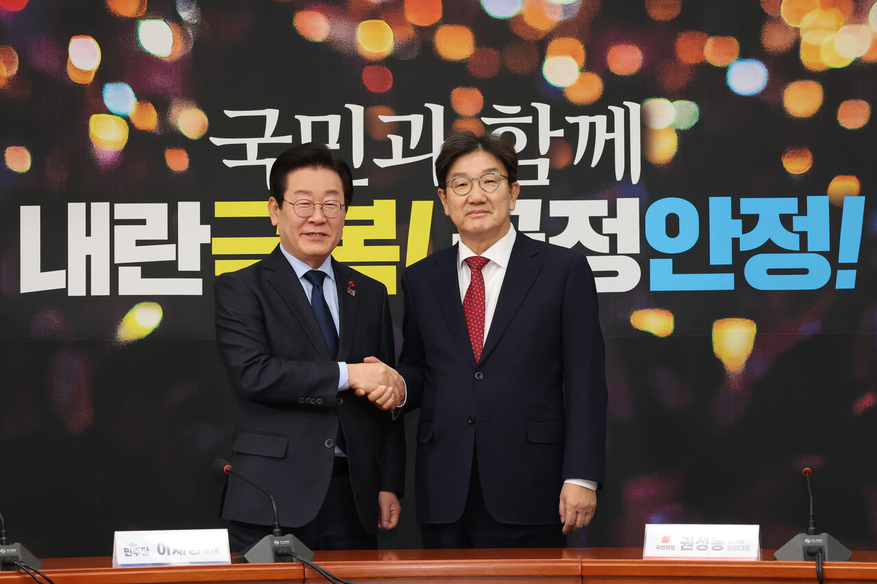 더불어민주당 이재명 대표가 18일 오후 서울 여의도 국회에서 예방한 국민의힘 권성동 원내대표(오른쪽)와 악수하며 기념 촬영하고 있다.