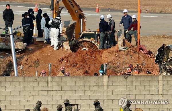 2일 오후 전남 무안군 무안국제공항 제주항공 참사 현장에서 합동조사단 관계자들이 로컬라이저 둔덕에 파묻힌 엔진을 꺼내는 작업을 하고 있다 [사진=연합뉴스]