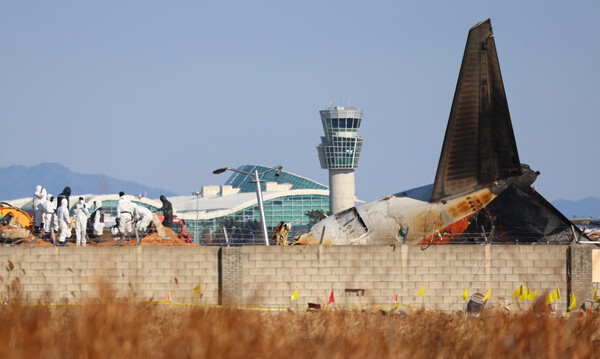 3일 오전 전남 무안군 무안국제공항 제주항공 여객기 참사 현장에서 항공철도사고조사위원회 및 국과수 관계자 등이 방위각시설(로컬라이저)에 파묻힌 엔진을 살펴보고 있다(연합뉴스)