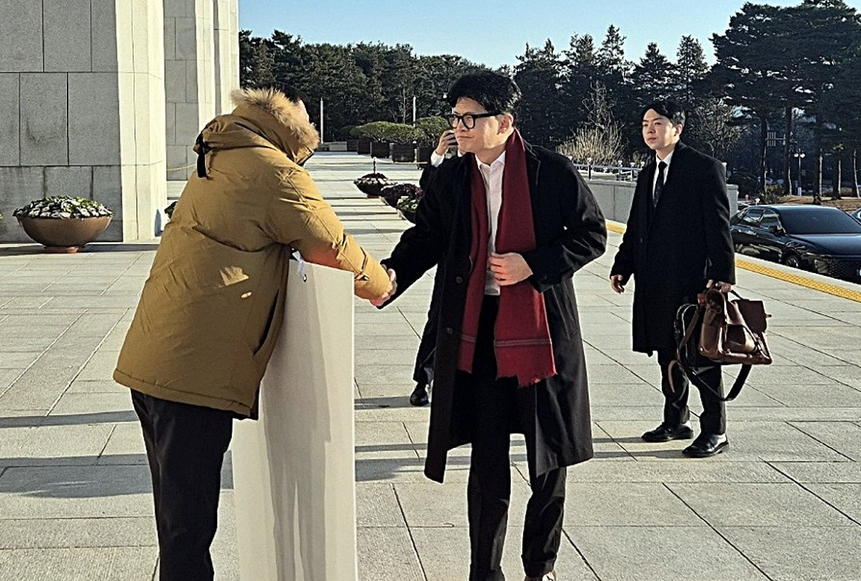 2024년 12월 14일 국민의힘 한동훈 대표가 국회 본청 앞에서 탄핵 찬성을 촉구하며 1인 시위를 하던 국민의힘 김상욱 의원에게 다가가 악수를 청하고 있다.