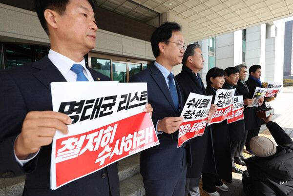 더불어민주당 명태균게이트 진상조사단이 14일 서울 서초구 대검찰청을 항의 방문하기 전 취재진 앞에서 손팻말을 들고 있다(연합뉴스)