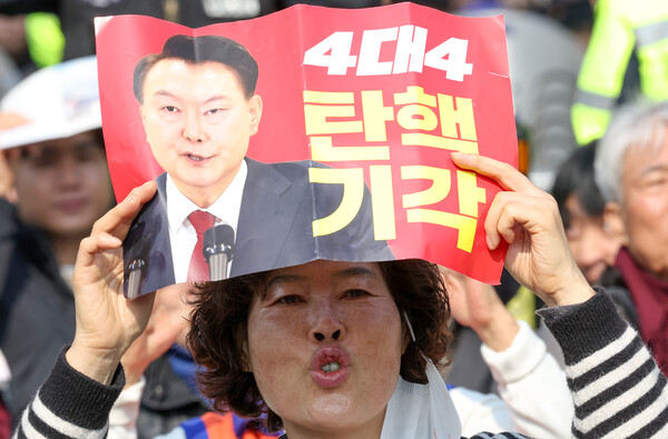 지난 9일 서울 용산구 한남동 대통령 관저 인근에서 열린 사랑제일교회 연합 예배에서 한 참가자가 탄핵 기각을 촉구하는 손팻말을 들고 있다(연합뉴스)