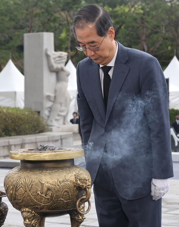한덕수 대통령 권한대행 국무총리가 19일 서울 강북구 국립 4·19민주묘지에서 열린 제65주년 4·19 혁명 기념식에서 헌화 및 분향을 마치고 묵념하고 있다(연합뉴스)