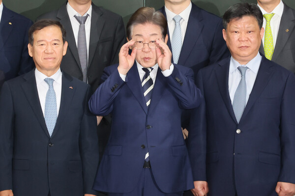 이재명 더불어민주당 대선 경선 후보가 21일 서울 여의도 금융투자협회에서 열린 자본시장 활성화를 위한 정책간담회에서 기념촬영 전 안경을 고쳐쓰고 있다 [사진=연합뉴스]