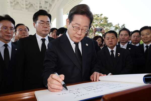 더불어민주당 이재명 대선 후보가 28일 동작구 국립서울현충원 참배를 마친 후 방명록 글을 작성하고 있다(연합뉴스)