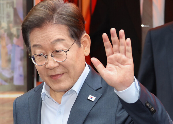 더불어민주당 이재명 대선 후보가 1일 서울 종로구의 한 포차 식당에서 '당신의 하루를 만드는, 보이지 않는 영웅들'이란 주제로 열린 배달 라이더, 택배 기사 등 비(非)전형 노동자들과의 간담회를 마친 뒤 나서며 손인사를 하고 있다 [사진=연합뉴스]