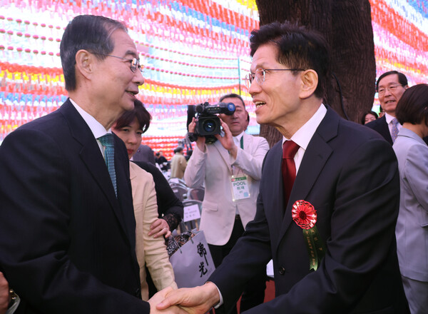 국민의힘 김문수 대선 후보(오른쪽)와 무소속 한덕수 대선 예비후보가 5일 서울 종로구 조계사에서 열린 불기 2569년 부처님오신날 봉축법요식을 마친 뒤 악수하고 있다(연합뉴스)