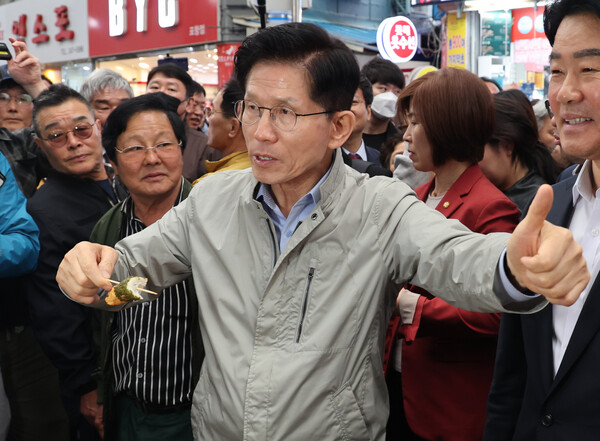 국민의힘 김문수 대선 후보가 6일 경북 포항시 죽도시장을 찾아 어묵을 먹으며 엄지를 치켜들고 있다(연합뉴스)