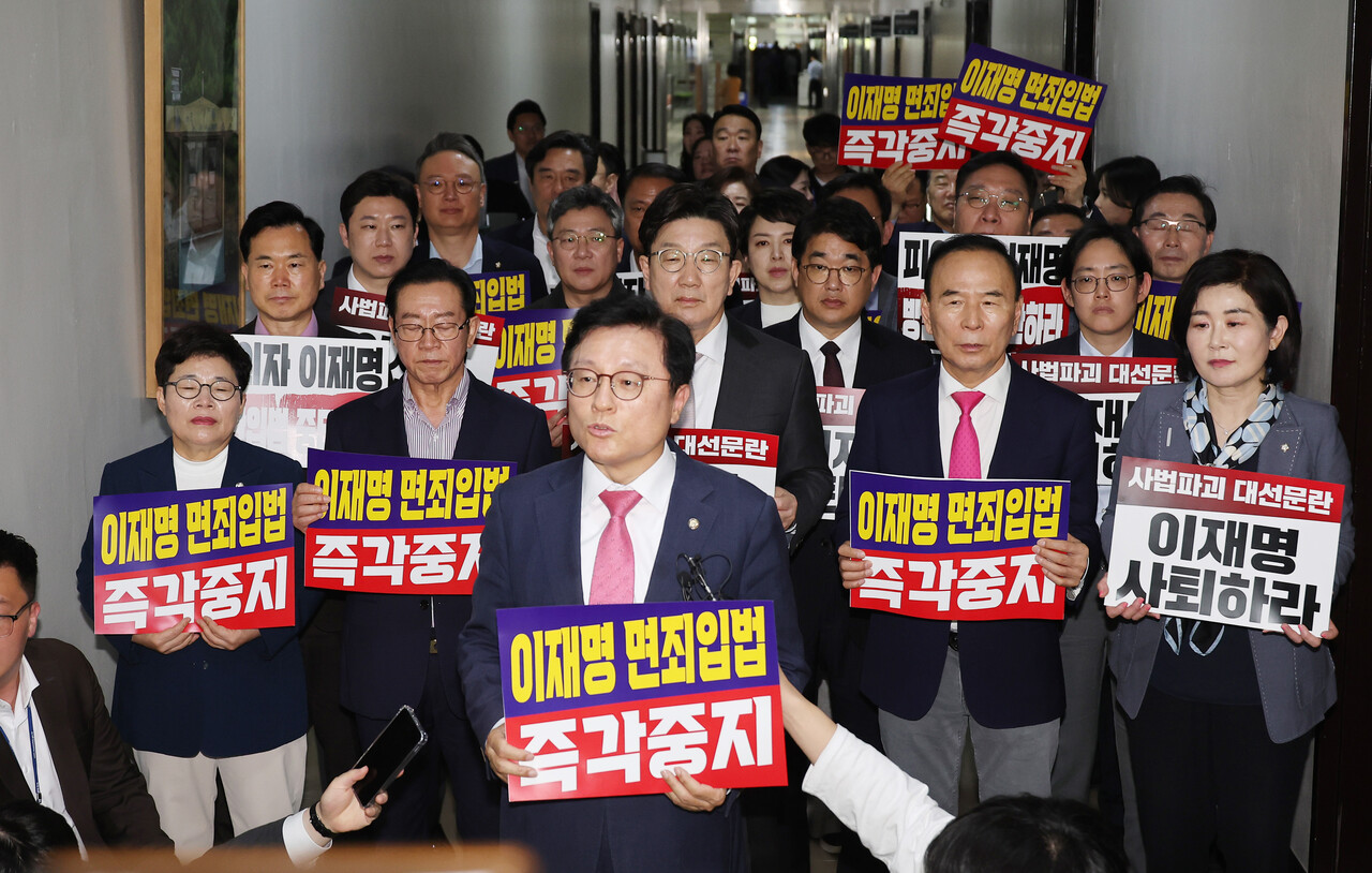 지난 7일 서울 여의도 국회 법제사법위원회 전체회의장 앞에서 국민의힘 의원들이 '이재명 면죄입법 즉각중지' 등의 내용이 적힌 손팻말을 들고 있다. 국회 법제사법위원회는 이날 법안심사소위원회를 열어 대통령 당선 시 진행 중인 형사재판을 정지하도록 하는 내용의 형사소송법 개정안을 의결했다.