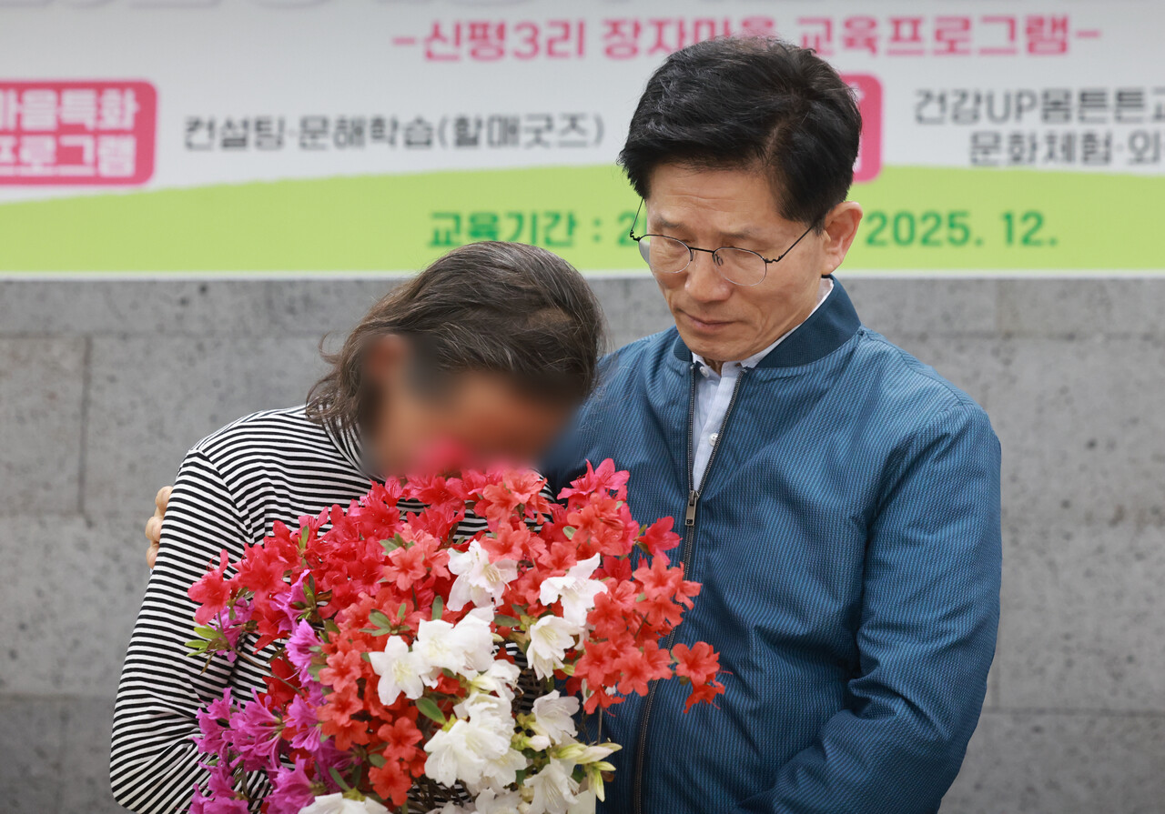 국민의힘 김문수 대선 후보가 지난 4일 한센인 마을인 경기도 포천시 장자마을을 방문해 간담회에서 편지를 읽은 주민이 전달한 꽃다발을 받은 뒤 주민을 위로하고 있다.(연합뉴스)