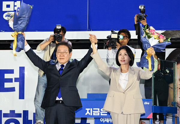 제21대 대통령 당선이 확실시되는 더불어민주당 이재명 대선 후보와 부인 김혜경 여사가 4일 서울 여의도 국회 인근에서 당 주최로 열린 국민개표방송 행사에 참석해 시민들을 향해 인사하고 있다(연합뉴스)