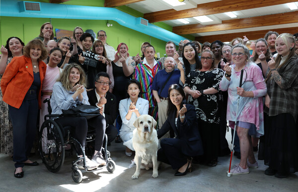 G7 정상회의에 참석하는 이재명 대통령과 함께 캐나다를 방문한 김혜경 여사가 17일(현지시간) 캘거리 국립장애인예술센터에서 은퇴 안내견‘벨라'와 센터활동가들과 기념촬영을 하고 있다(연합뉴스)