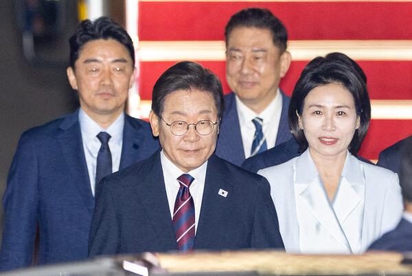 이재명 대통령과 김혜경 여사가 19일 51차 주요 7개국(G7) 정상회의 일정을 마친 뒤 성남 서울공항에 도착해 공군 1호기에서 내려 차량으로 향하고 있다. 뒤는 강훈식 대통령 비서실장과 더불어민주당 김병기 당 대표 직무대행 겸 원내대표(연합뉴스)