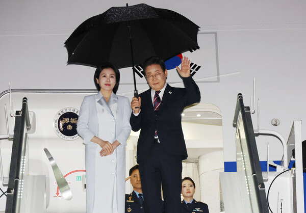 이재명 대통령과 김혜경 여사가 17일(현지시간) 51차 주요 7개국(G7) 정상회의 일정을 마치고 캐나다 캘거리국제공항에서 귀국하며 공군 1호기 올라 인사하고 있다(연합뉴스)