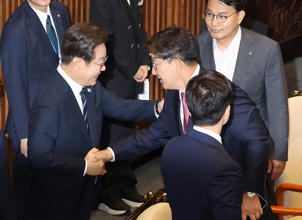 이재명 대통령이 26일 추가경정예산 시정연설을 마친 뒤 국회 본회의장에서 국민의힘 권성동 의원과 인사하고 있다(연합뉴스)