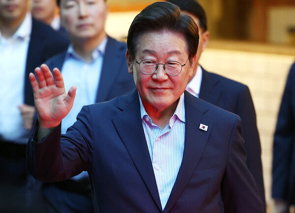 이재명 대통령이 11일 저녁 서울 광화문 인근 한식당에서 나오며 시민들에게 손을 흔들고 있다(연합뉴스)