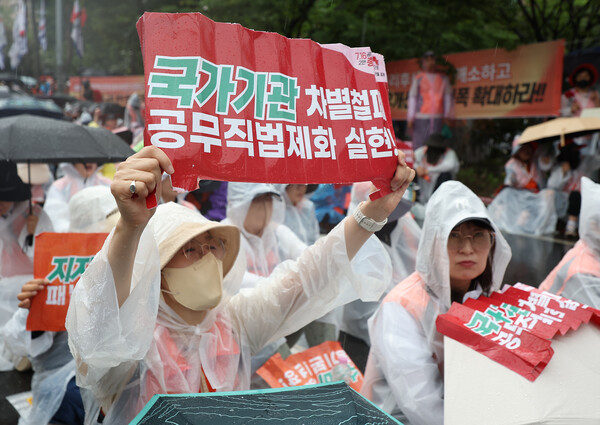 전국민주노동조합총연맹(민주노총)이 16일 서울 영등포구 국회 인근에서 연 수도권 총파업 대회에서 참가자들이 손팻말을 들고 있다(연합뉴스)