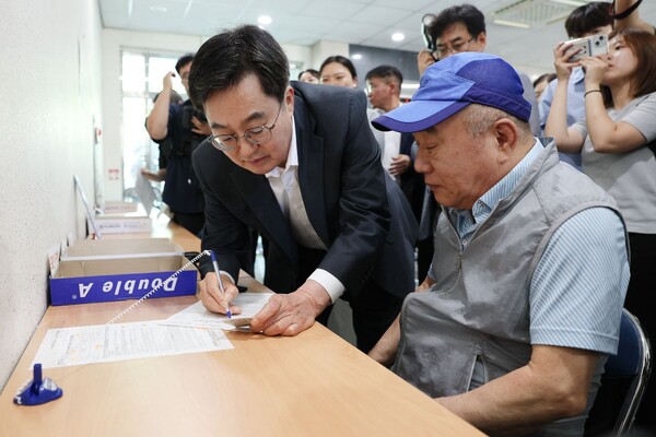 김동연 지사가 21일 오후 수원시 영통구 원천동행정복지센터를 방문해 민생회복 소비쿠폰 신청 어르신을 돕고 있다. ＠경기도