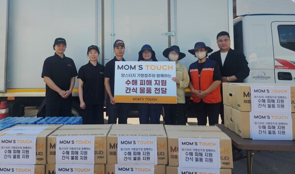 지난 8일 경남 산청군 신안면에 위치한 집중호우 피해 현장에서 맘스터치 본사 임직원 및 가맹점주들이 간식 물품을 전달하고 수해복구 현장 관계자들과 기념촬영을 진행하고 있다. (왼쪽부터) 김성훈·곽은주 맘스터치 함양점 점주, 이종민 경상대점 점주, 박혜나 경상남도 자원봉사센터 부장, 반영경 경상남도 산청군청 복지정책과 계장, 자원봉사자, 강한성 맘스터치 전략지원부문장 [사진제공=맘스터치앤컴퍼니]