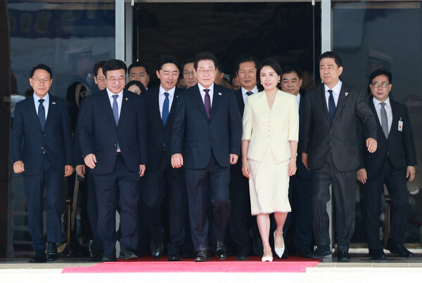 이재명 대통령과 김혜경 여사가 일본·미국 방문을 위해 23일 성남 서울공항청사를 나서며 윤호중 행안부 장관, 더불어민주당 정청래 대표, 김병기 원내대표 등과 함께 공군 1호기로 향하고 있다. [연합뉴스]