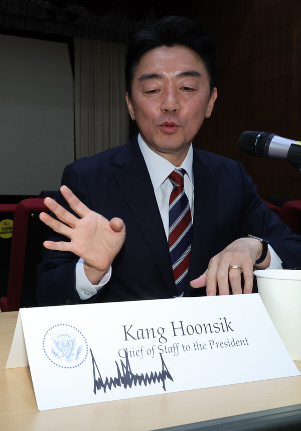 강훈식 비서실장이 28일 용산 대통령실에서 기자간담회 중 트럼프 대통령에게 본인이 받은 선물에 대해 설명하고 있다. 그 앞에 트럼프 대통령이 사인한 오찬장 비서실장 명패가 있다(연합뉴스)