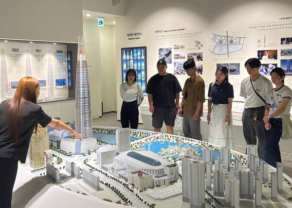 신격호 기념관을 방문한 학생들이 롯데월드타워, 롯데월드 어드벤처 등 롯데를 상징하는 건물들에 대한 설명을 듣고 있다. 사진 제공=롯데.