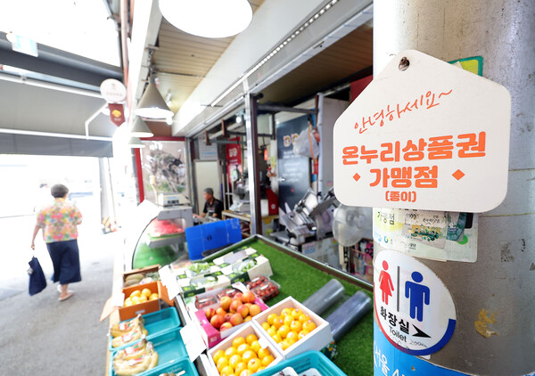 정부가 민생회복 소비쿠폰 1차 지급계획을 발표한 6일 서울의 한 전통시장 점포에 기존 골목경제 소비 활성화를 위한 온누리상품권 가맹 팻말이 붙어 있다. 정부가 지급하는 소비쿠폰은 온·오프라인에서 모두 사용할 수 있는 방식으로 지급될 예정이다. [연합뉴스]