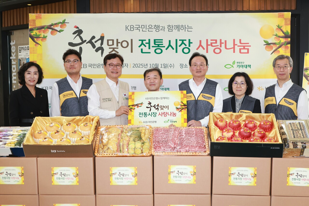 1일 서울 마포구에 위치한 망원시장에서 최창남 기아대책회장(왼쪽에서 세번째), 김은종 망원시장 상인회장(왼쪽에서 네번째), 이환주 KB국민은행장(왼쪽에서 다섯번째) 및 관계자들이 기념 촬영을 하고 있다.