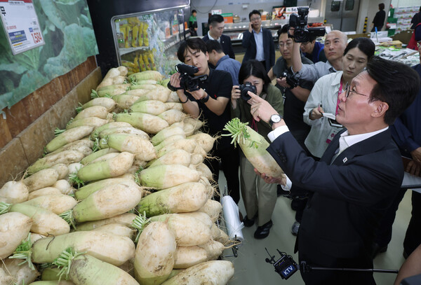 김민석 국무총리가 22일 추석 맞이 물가 현장점검을 위해 양재동 농협 하나로마트를 방문, 무 가격을 점검하고 있다(연합뉴스)