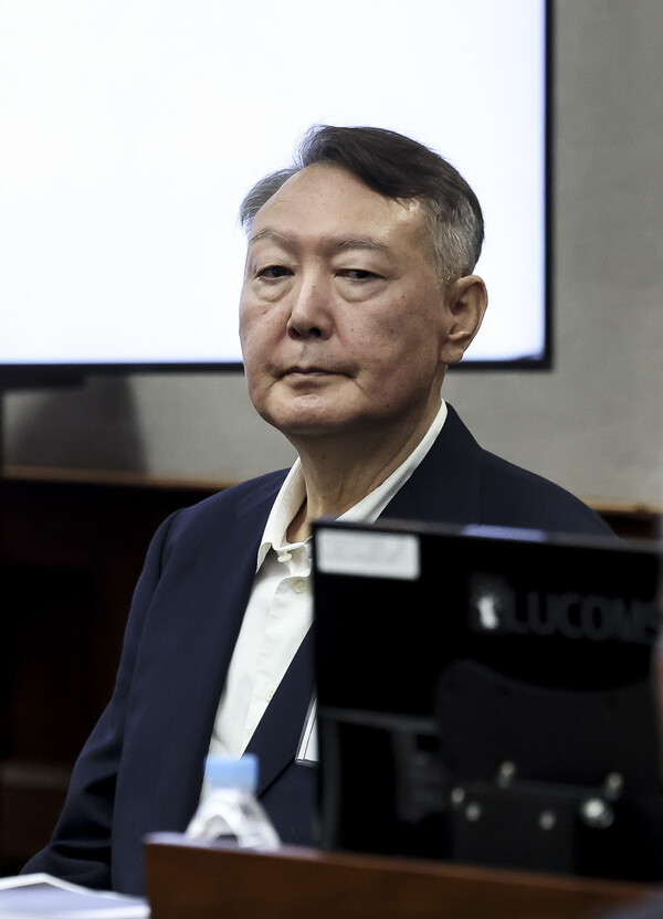  윤석열 전 대통령이 26일 서울 서초구 서울중앙지법에서 열린 특수공무집행방해, 직권남용 권리행사방해 등 혐의 사건 1차 공판에 출석해 있다(연합뉴스)