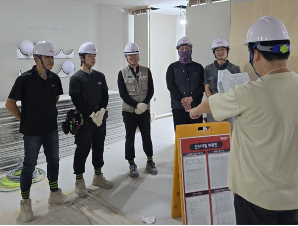오스템임플란트 인테리어 시공팀이 현장 작업 전 안전 교육을 하는 모습. 사진 제공=오스템임플란트.