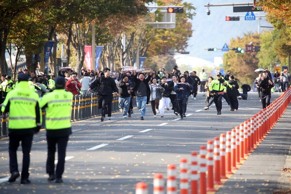 29일 오후 한미 정상회담이 열린 국립경주박물관 인근에서 도널드 트럼프 미국 대통령을 반대하는 기습 시위대가 경찰저지선을 뚫고 정상회담장으로 질주하고 있다(연합뉴스)