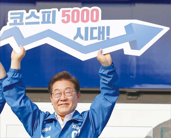 이재명 대통령이 지난 5월 대선 과정 중 서울 고속버스터미널 앞에서 열린 서초구·강남구 유세에서 ‘코스피 5000 시대’를 들어 보이며 경제 회복 퍼포먼스를 하고 있다. [사진=연합뉴스]