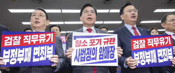 국민의힘 송언석 원내대표(가운데)와 김도읍 정책위의장(왼쪽), 유상범 원내 운영수석부대표가 10일 국회에서 열린 의원총회에서 검찰의 대장동 개발 비리사건 항소 포기를 규탄하는 손팻말을 든 채 규탄 구호를 외치고 있다.(연합뉴스)