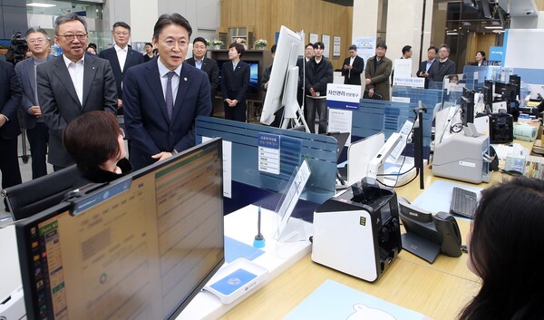 19일 서울시 중구 소재 신한은행 광교영업부에서 진행된 ‘오프라인 오픈뱅킹·마이데이터 서비스 시연행사’에서 정상혁 신한은행장(뒷편 왼쪽)과 금융위원회 권대영 부위원장(오른쪽)이 서비스에 대한 직원 설명을 듣고 있는 모습. 사진 제공=신한은행.
